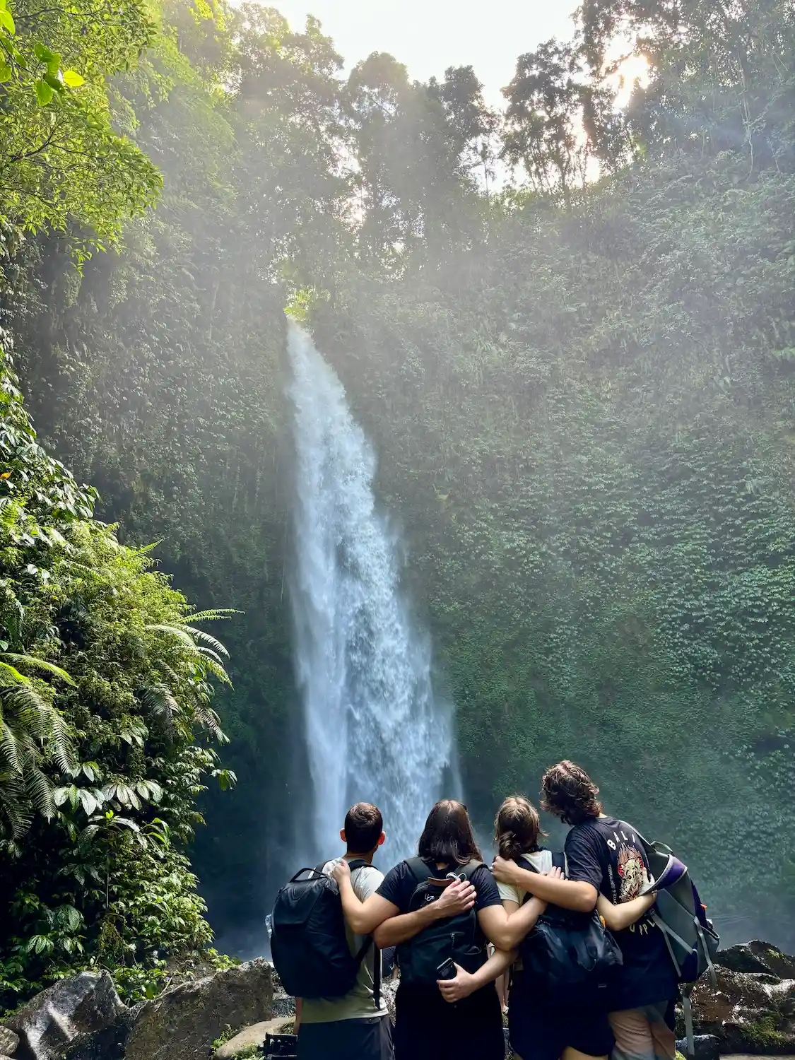 Group photo of Tanya and her friends looking at a waterfall in Bali, Indonesia